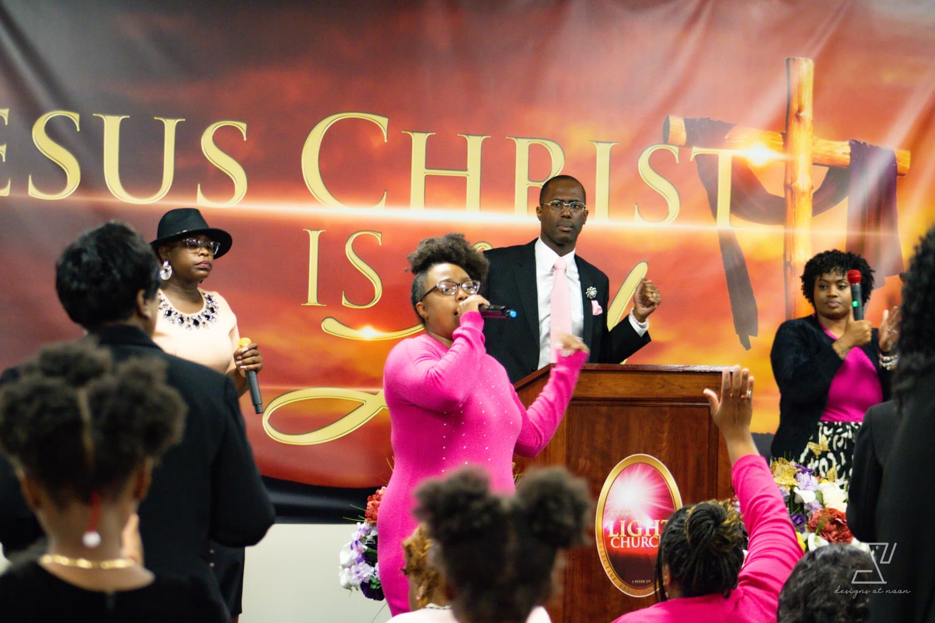 Praise leader singing into a microphone as the congregation worships