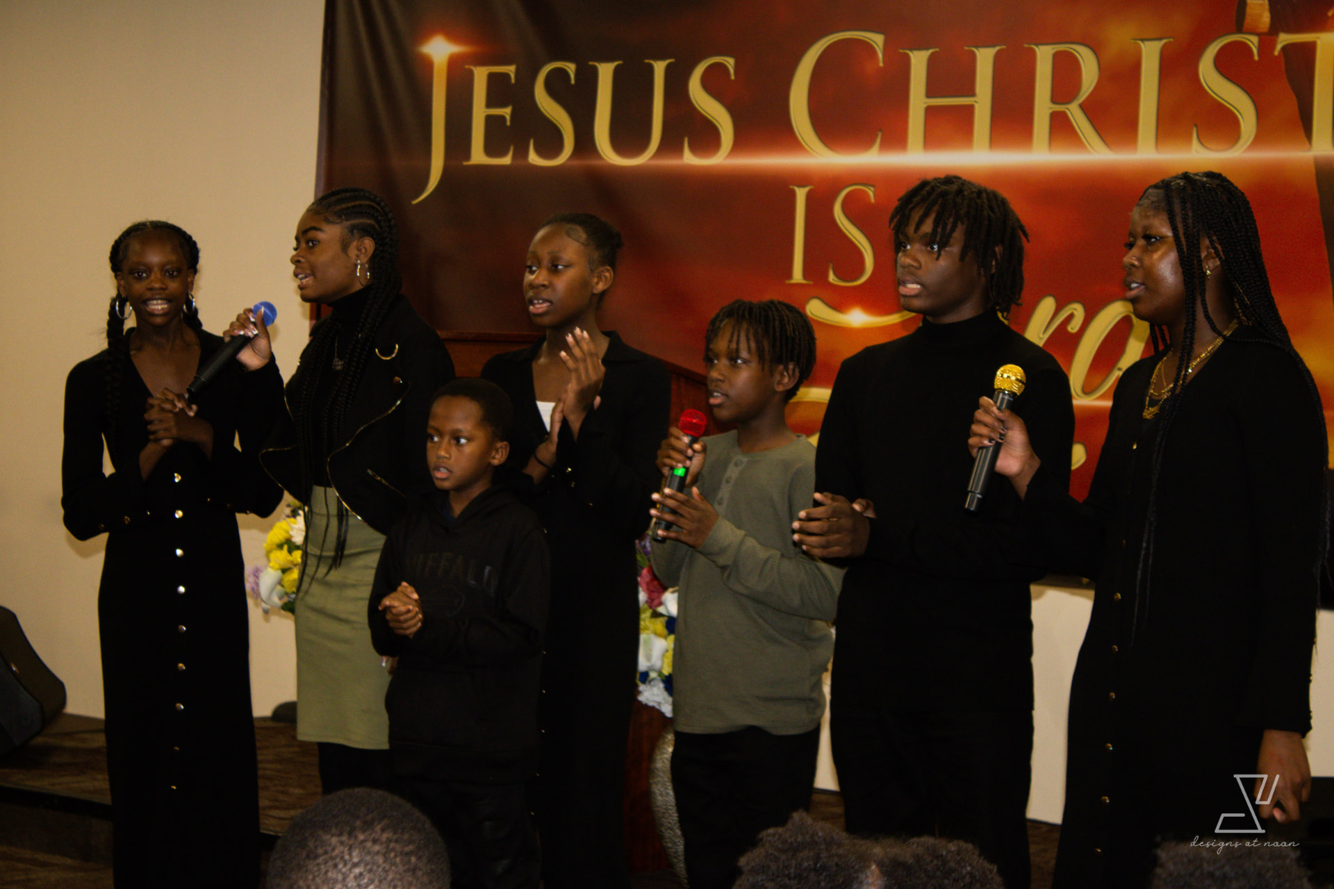 Youth choir singing together in black attire during a church service